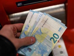 Euro-Scheine vor einem Geldautomaten