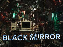 Ein überfüllter Raum mit Kabeln und Monitoren, in der Mitte ein Computer. Text: 'BLACK MIRROR'.