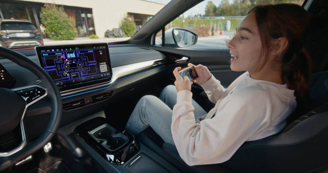 Frau spielt Pac-Man in einem VW.