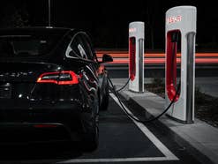 Tesla: Das Drama mit E-Autos findet einen neuen Höhepunkt Ein schwarzes E-Auto von Tesla steht an einem Supercharger.